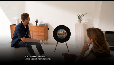 Two people sitting in a modern living room with a decorative item on a stand.