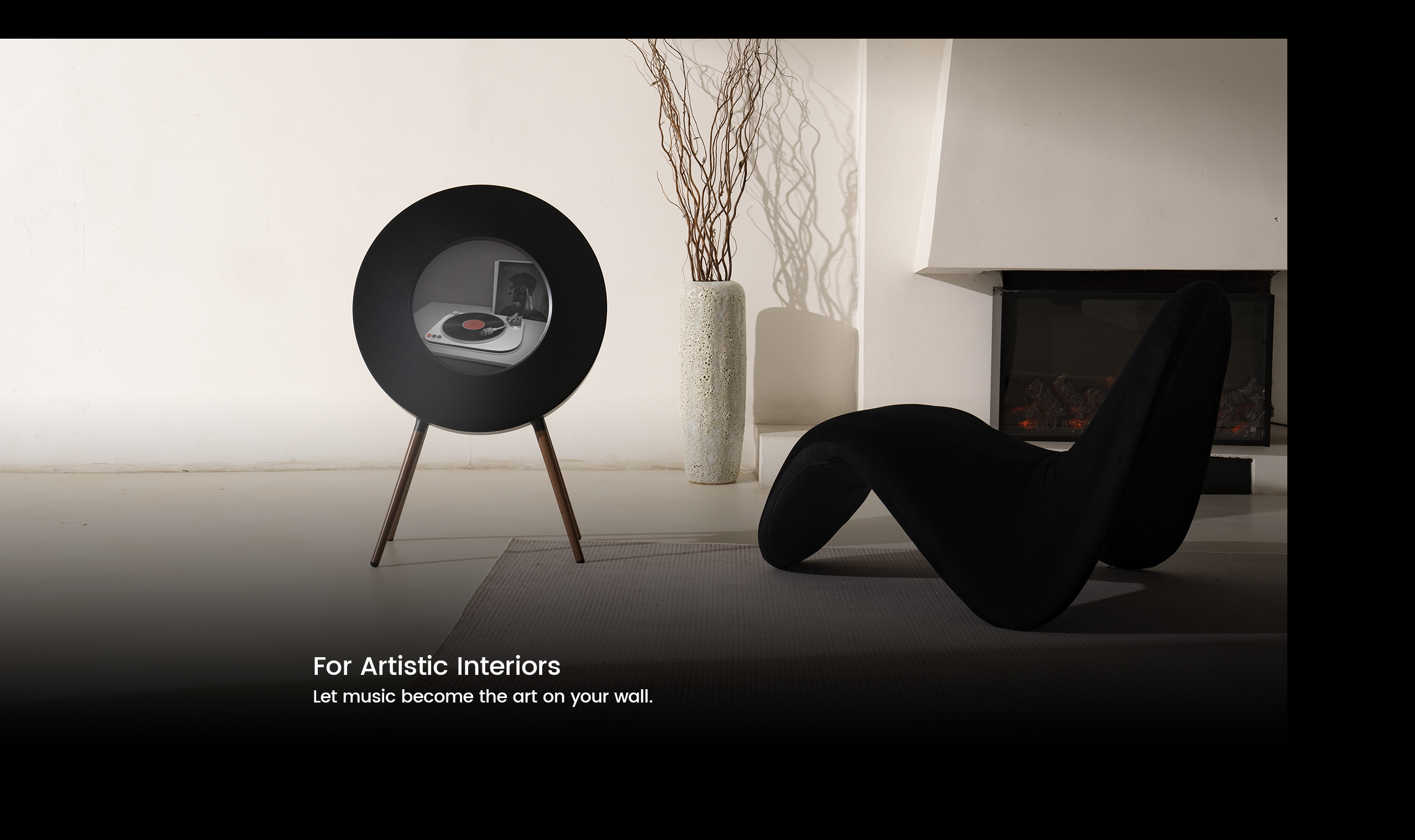 Modern black speaker in a minimalistic room with a vase and chair.
